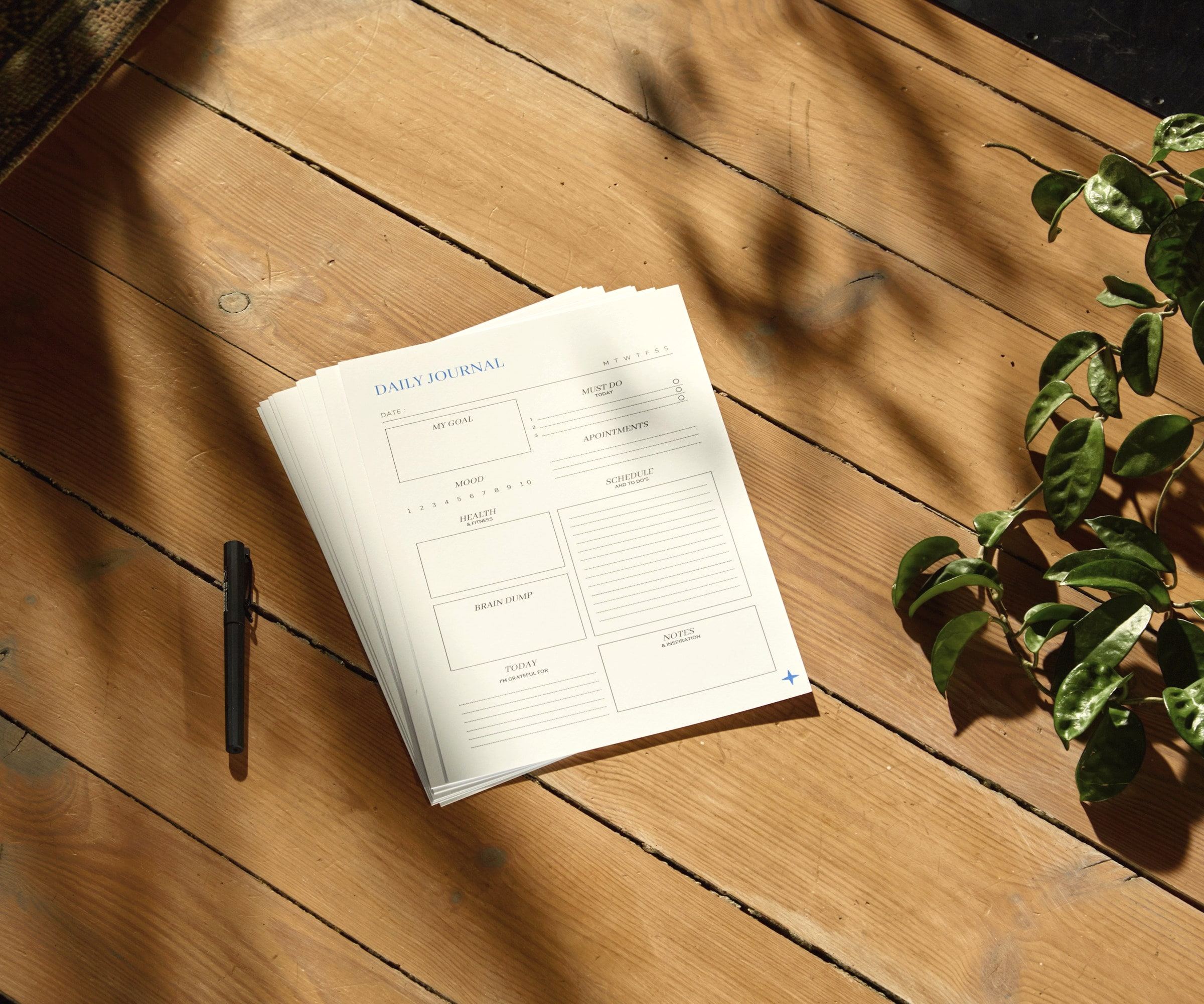 A printed planning sheet and a pen on a sunlit wooden table.
